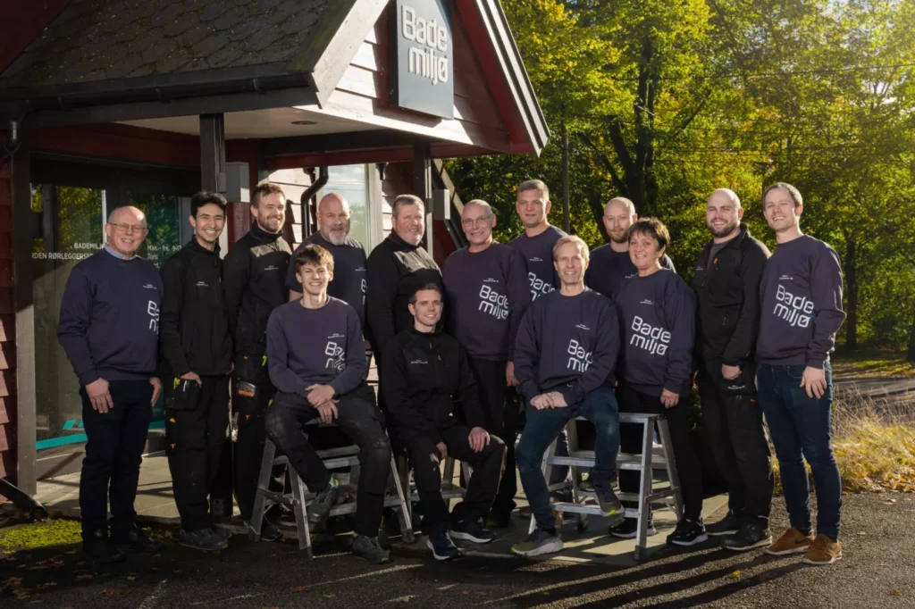 Gruppe bilde av ansatte hos Gården Rørleggerservice ved inngangsparti til butikken.